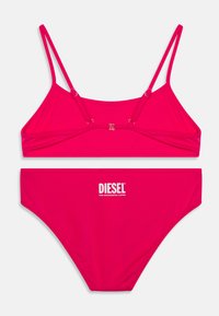 Rosa bikini-set gjort av slät tyg. Toppen har tunna justerbara remmar och ett framknäpp. Underdelen har en logotyp tryckt i vitt.