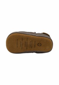 Suola di scarpa in pelle marrone con parte inferiore in gomma texturizzata color sabbia. Presenta testo stampato e logo, forma arrotondata e un leggero arco per il supporto.