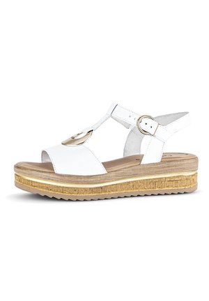 White platform sandals with a cork-like sole, rounded design, adjustable ankle strap, and circular gold accent detail.