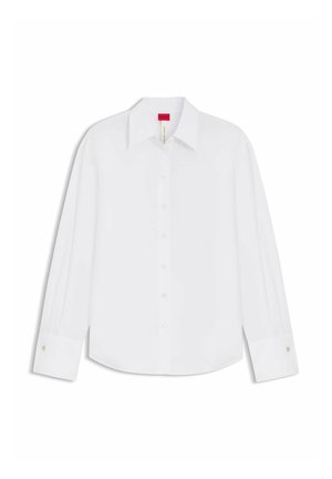 Camicia bianca a maniche lunghe con bottoni, colletto e polsini, mostrata distesa con etichetta del marchio rossa visibile all'interno del colletto.
