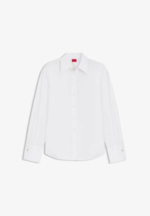 Camicia bianca a maniche lunghe con bottoni, colletto e polsini, mostrata distesa con etichetta del marchio rossa visibile all'interno del colletto.