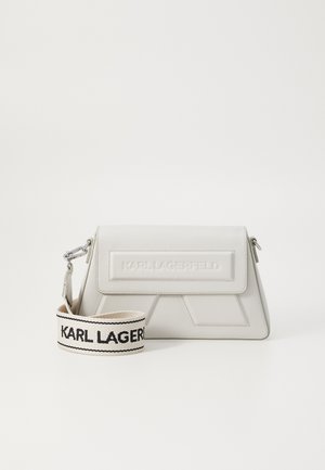 Sac à main blanc Karl Lagerfeld avec rabat rectangulaire et bandoulière blanche amovible portant le nom de la marque en noir.