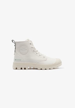 Bottes montantes blanches en cuir lisse avec une semelle en caoutchouc texturée. Équipées d'un patch logo rond et d'une languette à l'arrière.