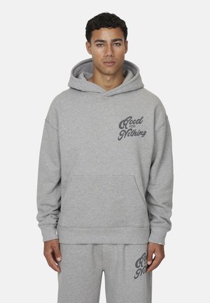 Felpa grigia con tasca frontale, dotata di polsini spessi e cappuccio con coulisse. Presenta il logo "Good for Nothing" in grigio scuro.