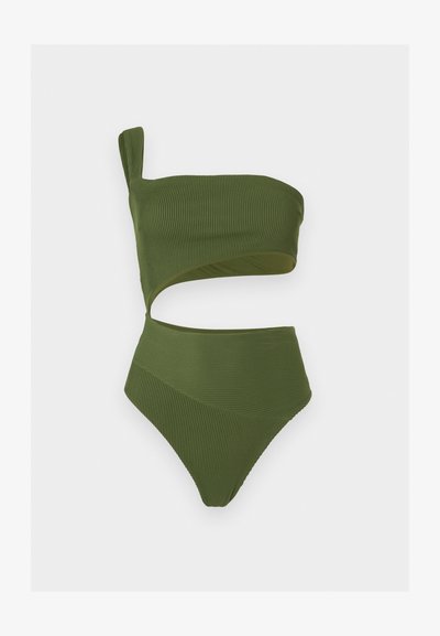 Ριμπ πλεκτό ολόσωμο μαγιό σε ελιά πράσινο με έναν ώμο, ασύμμετρο άνοιγμα στη μέση και ψηλές ανοίγματα στα πόδια.