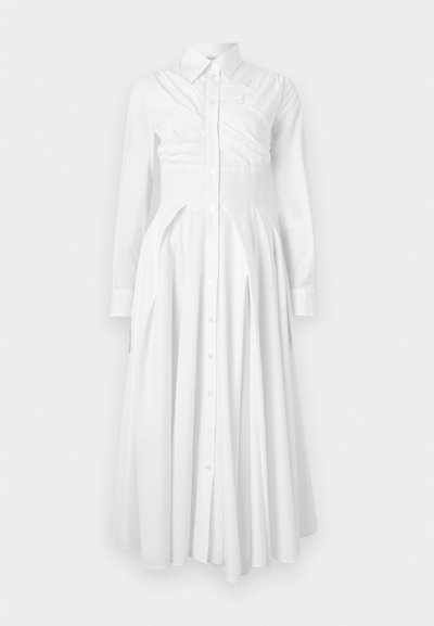 White cotton shirt dress with long sleeves, button-down front, pleated skirt, and fitted waist. Features a structured design and soft texture.