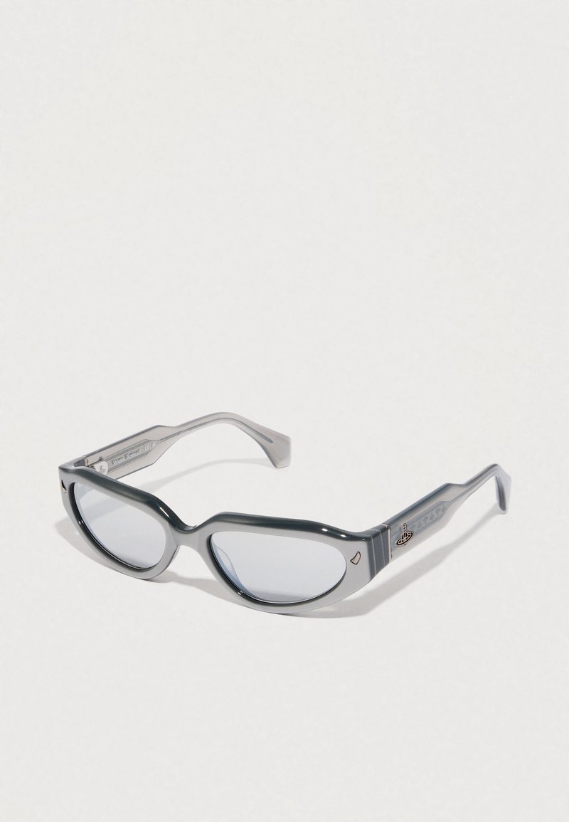 Gafas de sol de plástico gris con forma de ojo de gato, lentes transparentes y acentos distintivos en las varillas. Presentan un acabado pulido.