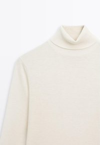 Pull à col roulé en crème pâle, fabriqué dans un tissu tricoté doux. Présente un design ajusté avec un col haut et des manches longues.