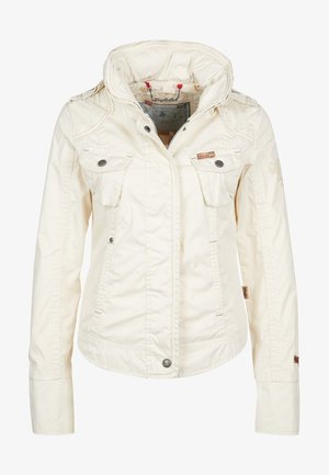 Veste blanche légère avec capuche, fermeture éclair à l'avant, deux poches poitrine et poches latérales. Tissu texturé avec détails décoratifs de couture.