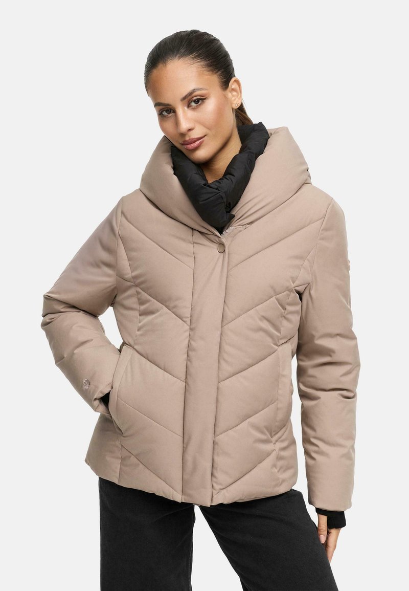 Veste matelassée beige avec un grand col noir, motif en chevron et boutons sur le devant. Elle dispose de poches latérales et d'une texture lisse.