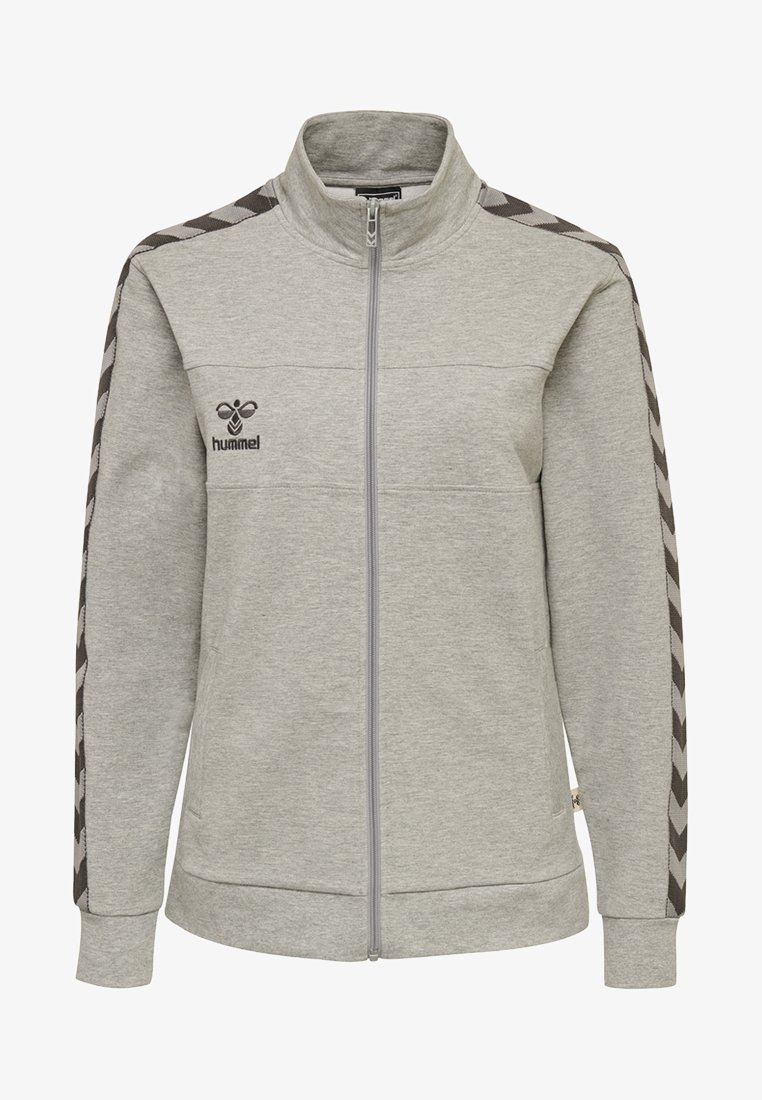 Grå zip-up sportjacka med hög krage, strukturerad tyg och svarta chevron-accenter längs ärmarna. Logotyp på vänster bröst.