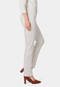 Lichtbeige rechte pijpen broek met een elastische tailleband en zijzakken, gecombineerd met bruin suède hoge hakken.