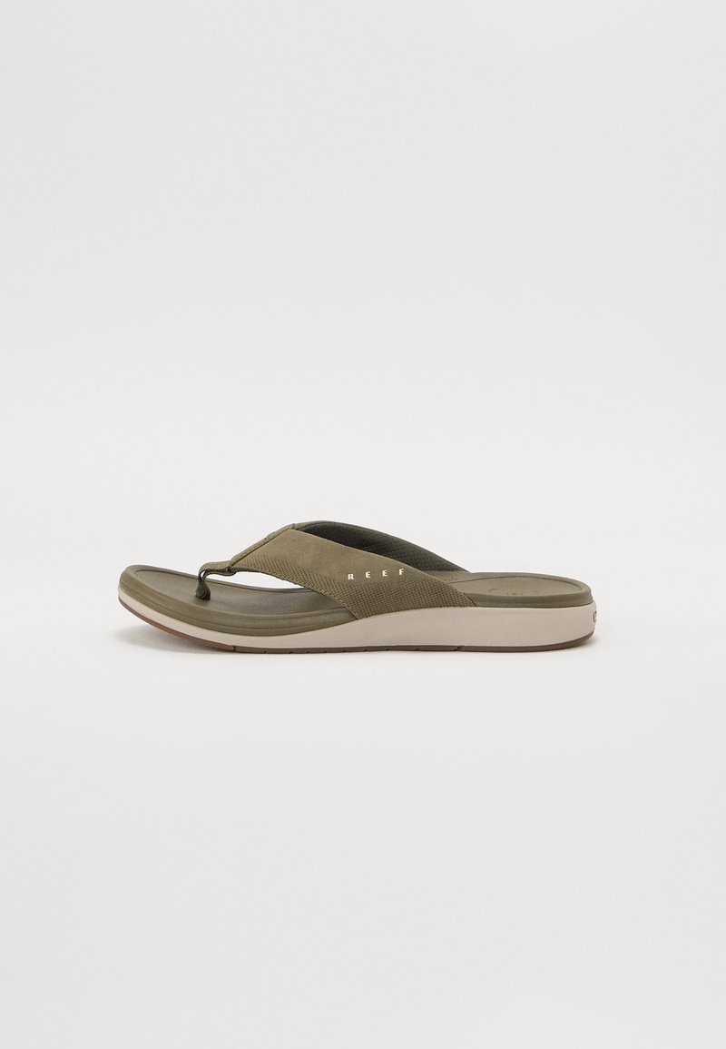 Olíva zöld flip-flop szandál texturált pánttal, puha talppal és világos színű talppal. Könnyű kialakítása a kényelem érdekében készült.