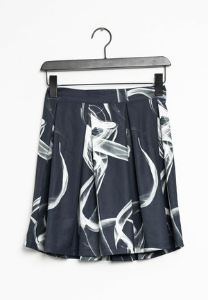 Czarna plisowana spódnica z białymi abstrakcyjnymi wzorami przypominającymi dym, zawieszona na czarnym wieszaku na białym tle.