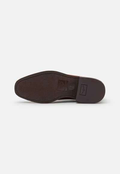 Suela de zapato de cuero marrón con una superficie texturizada, forma redondeada y una impresión de logo. El tacón está ligeramente elevado, con bordes suaves.