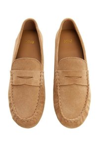 Nahkakengät vaaleassa ruskeassa sävyssä, joissa on mokkaasuunnittelu, pienet koristeleikatut yksityiskohdat ja ompeleita pohjan ympärillä.