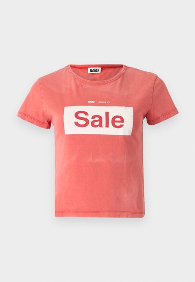 Red short-sleeve t-shirt made of cotton, featuring a white box with "Sale" in bold red lettering, and a round neckline.