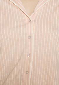 Rosa Hemd mit weißen gepunkteten Streifen, aus softem Stoff, mit Kragen und sichtbaren Knöpfen entlang der vorderen Leiste.