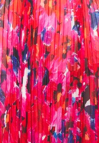 Faltbarer Stoff mit einem lebhaften Blumendesign in den Schattierungen Pink, Rot und Blau, der ein strukturiertes, mehrschichtiges Aussehen schafft.