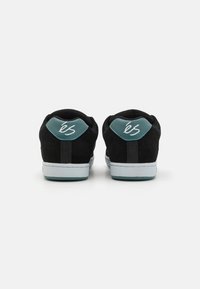 Mustad nubukist sneakers tealist aksentidega, valgete kummitaldadega ja silmapaistva logoga kandadel. Minimalistlik disain sujuva tekstuuriga.