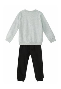 Grauer Sweatshirt mit gerippten Bündchen und Saum, kombiniert mit schwarzen Jogginghosen, die einen elastischen Bund und gerippte Knöchelbündchen haben.