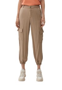 Pantalones cargo beige con puños elásticos, dos bolsillos frontales y dos bolsillos laterales con solapa. Fabricados con una tela ligera de textura suave.
