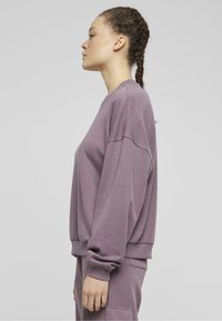 Överdimensionerad lila sweatshirt i mjukt tyg, med rund halsringning och ribbade ärmslut. I kombination med matchande underdel.