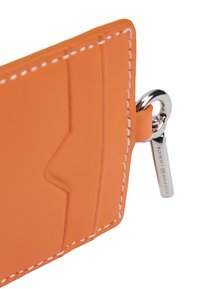 Πορτοκαλί δερμάτινη θήκη καρτών με λευκό ράψιμο, διαθέτοντας πολλαπλές θήκες για κάρτες και ασημένιο κρίκο κλειδιών με ετικέτα бренδ.