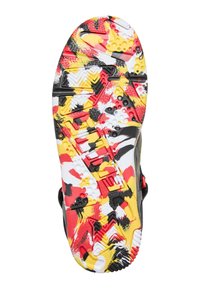 Suela de zapato con una base negra y un patrón colorido de rojo, amarillo y blanco. Gomas texturizadas y formas variadas mejoran la tracción.