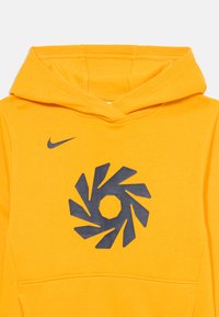 Žltá mikina vyrobená z bavlny, so veľkým námorníckym grafickým dizajnom v strede, klokaními vreckami a kapucňou so šnúrkou.