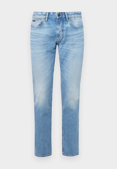 Vaaleansiniset farkut, joissa on suora lahje, haalistuneet yksityiskohdat, viisi taskua sekä klassinen nappi- ja vetoketjukiinnitys.