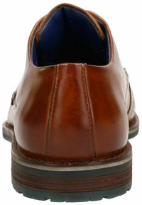 Chaussure en cuir marron avec un bout rond, des détails cousus et un intérieur texturé bleu. Elle possède une semelle en caoutchouc à construction superposée.