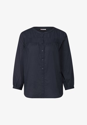 Chemise à manches longues bleu foncé avec un col rond, fermeture à bouton et détails froncés sur la partie supérieure. Fabriquée en tissu léger.