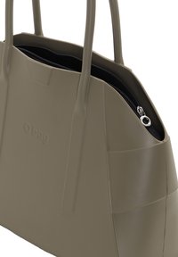 Bolso tipo tote de color verde oliva hecho de material suave y duradero, con dos asas, cierre de cremallera y un logo sutil en relieve.