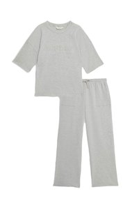 Grijze loungewear set met een korte mouw top voorzien van de tekst "SUNDAY" en losse, elastische taillebroek met zijzakken.