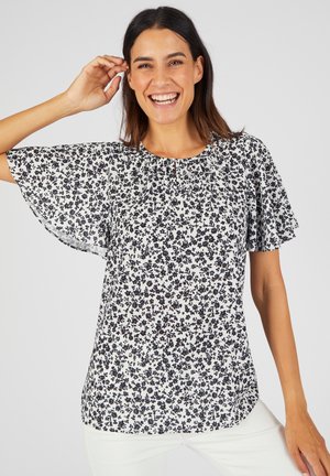 Witte blouse met korte mouwen en een zwart bloemenpatroon, met een geschulpte halslijn en zachte, lichtgewicht stof.