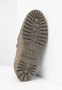 Semelle de chaussure en cuir suédé beige avec des crampons profonds et multidirectionnels pour une meilleure adhérence. Dispose d'une étiquette indiquant "NeroGiardini" et "Fabriqué en Italie." Taille 37.