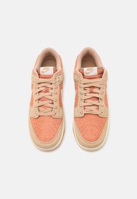 Nike sneakers med en persikofärgad mockaöverdel, beige accenter, perforerat tåbox och beige gummisula. Inkluderar krämfärgade snören och logotags.