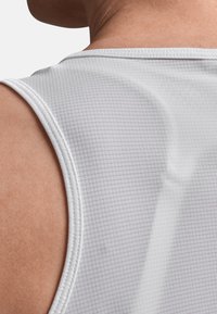 Hvid ærmeløs atletisk tanktop med et tekstureret gittermønster, ribbet kant og en afslappet pasform designet til komfort og åndbarhed.