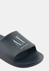 Sandalo nero con design aperto sulla punta. Presenta una finitura testurizzata e una stampa del logo bianca. Realizzato in materiale sintetico resistente.