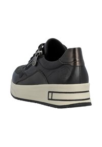 Sneaker en cuir noir avec un design texturé, détail de fermeture éclair sur le côté et semelle crème avec des rayures noires. Bout arrondi et construction robuste.