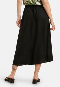 Black, ankle-length skirt with a gathered elastic waistband; made of lightweight fabric; features a smooth, slightly textured surface.