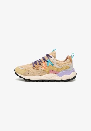 Baskets avec tige en polaire beige, panneaux en daim multicolores, lacets violets et semelle épaisse avec des détails de semelle en lavande et noir.