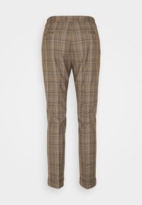 Pantalon slim à carreaux marron avec poches passepoilées à l’arrière et coupe fuselée, présenté sur un fond uni.