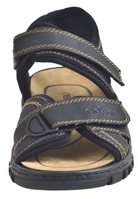 Schwarze Ledersandale mit Kreuzriemen und beigem Näht, Korkeinlegesohle und Gummisohle. Verstellbare Klettverschlüsse.