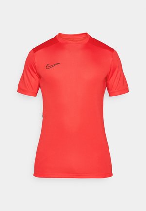 Crvena Nike sportska majica kratkih rukava, okruglog izreza, s crnim logom na prsima. Izrađena od glatkog, rastezljivog materijala.