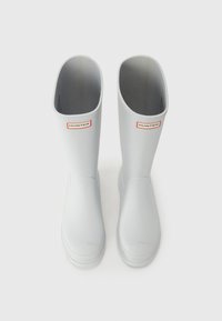 Gray rubber rain boots with a smooth texture, rounded tops, and a small red logo on the front. Dual openings at the top for easy wear.