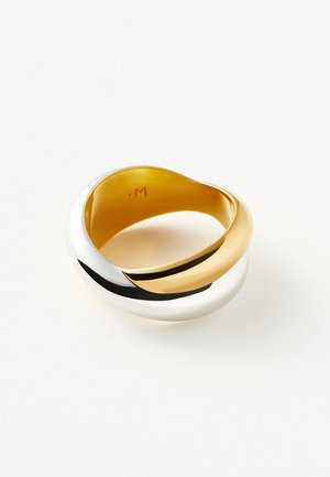 Anillo redondo entrelazado de oro y plata con acabado suave y pulido sobre un fondo blanco liso.