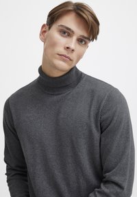 Tumehall villane kaelus-sweater, mis on valmistatud pehmest kangast, omades ribakujulist kaelust ja pikki varrukaid, sujuva tekstuuri ja keha külge liibuva disainiga.
