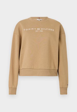 Ruda sportinė palaidinė su raukšlėmis ant rankovių ir apykaklės. Priekyje puikuojasi balta "TOMMY HILFIGER EST. 1985" logotipas. Minkšta tekstūra, laisvas kirtimas.